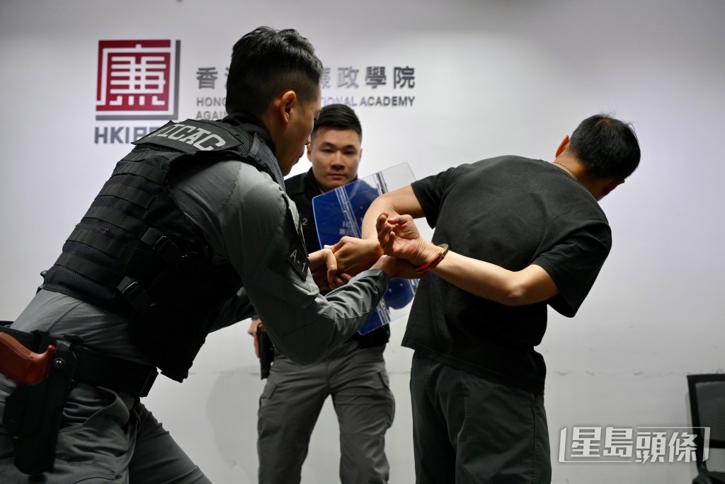 參加者在廉署人員指導下,親身體驗使用手銬進行模擬拘捕行動。 參加者在廉署人員指導下,親身體驗使用手銬進行模擬拘捕行動。