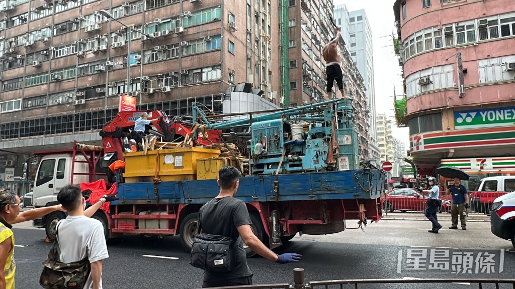 赤膊男危站吊臂車的機器上，離地約4米高。劉漢權攝