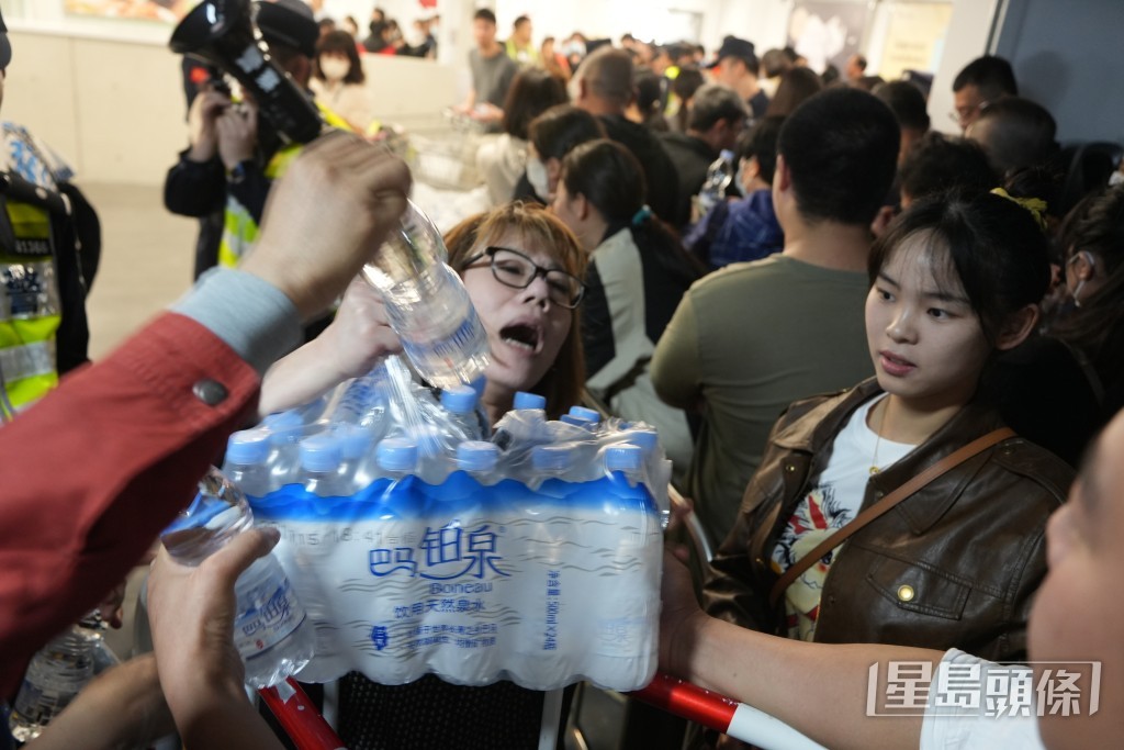 职员向排队人士派发樽装水。吴艳玲摄