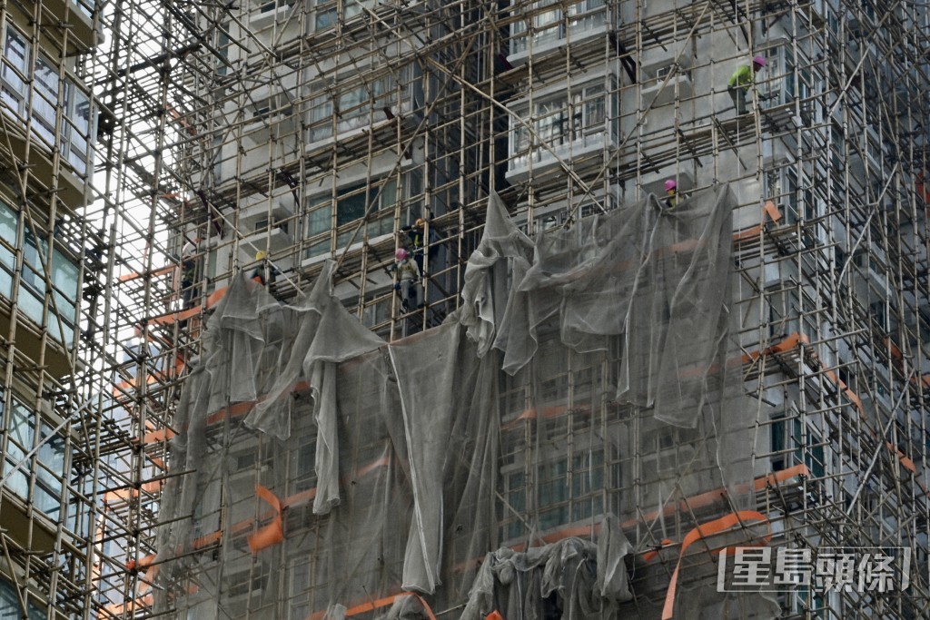 《星島頭條》記者下午到怡樂花園視察,有工人正在外牆棚架上拆除棚網。 《星島頭條》記者下午到怡樂花園視察,有工人正在外牆棚架上拆除棚網。