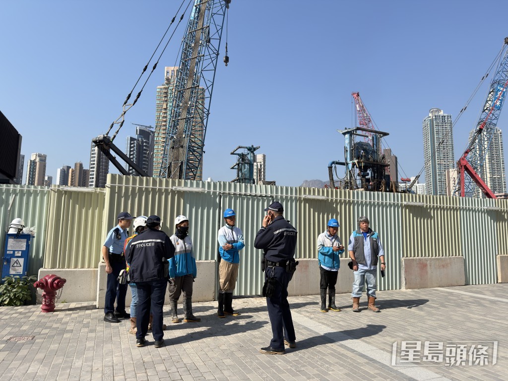 警員向工友了解事件。
