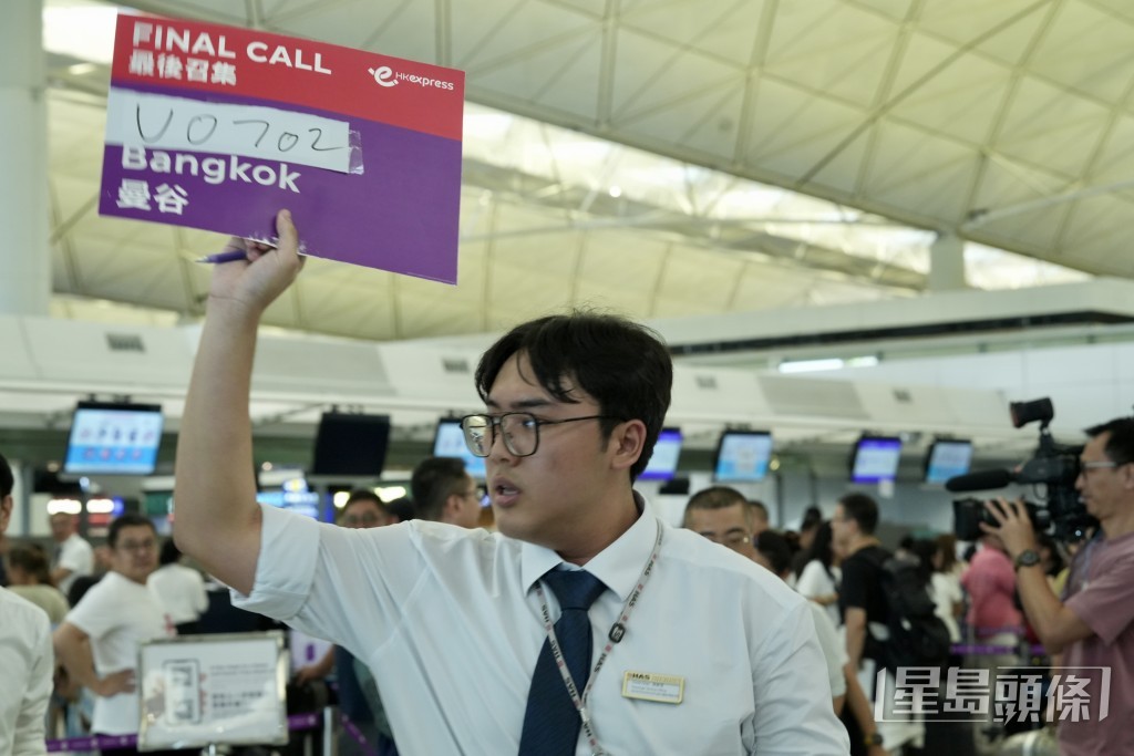 昨日有航空公司職員用手寫牌安排乘客登機。劉駿軒攝