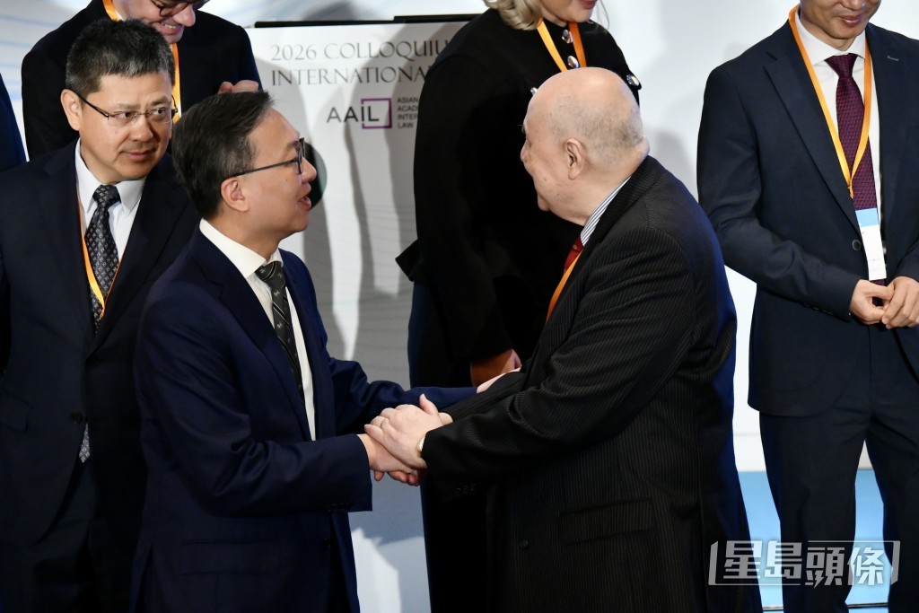 林定國與梁定邦握手示意。 林定國與梁定邦握手示意。