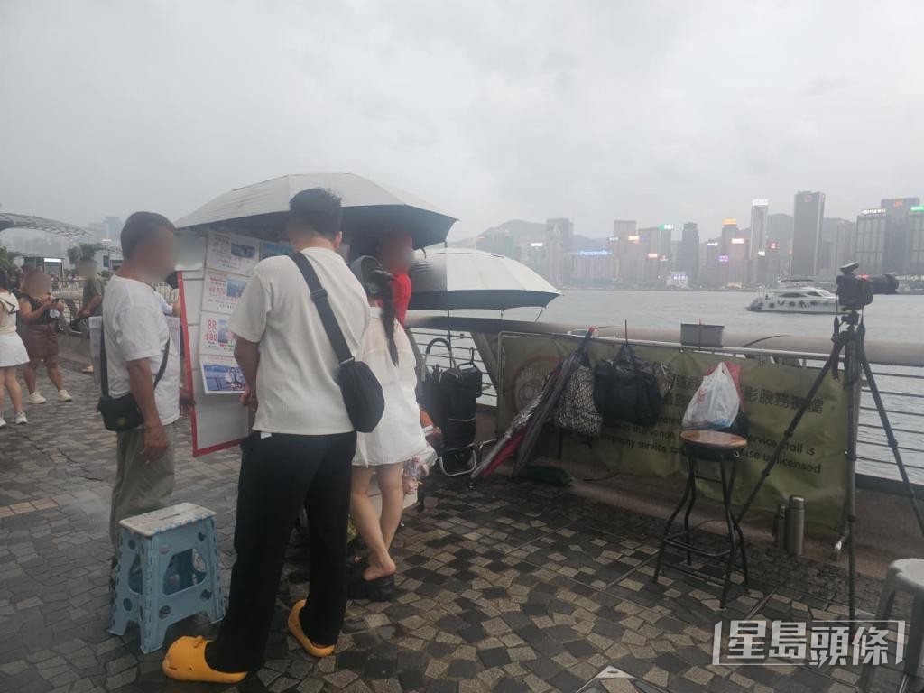 旅客上前詢問攤檔收費。 旅客上前詢問攤檔收費。