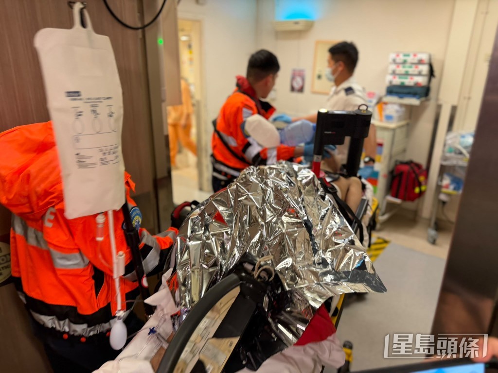 救護員為昏迷男子安上自動心外壓機，送伊利沙伯醫院搶救。曾志恆攝