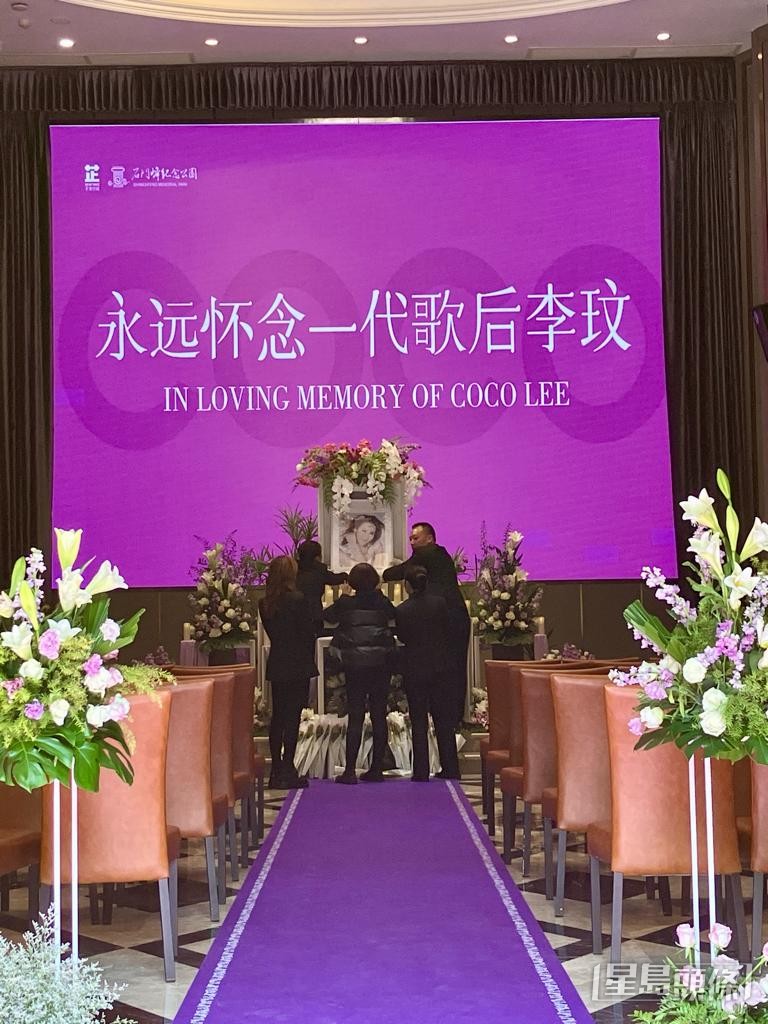 李玟去年10月安葬於武漢石門峰紀念公園，​工作人員在李思林（左一）及李秋林（中）指示下擺放好李玟的遺照。