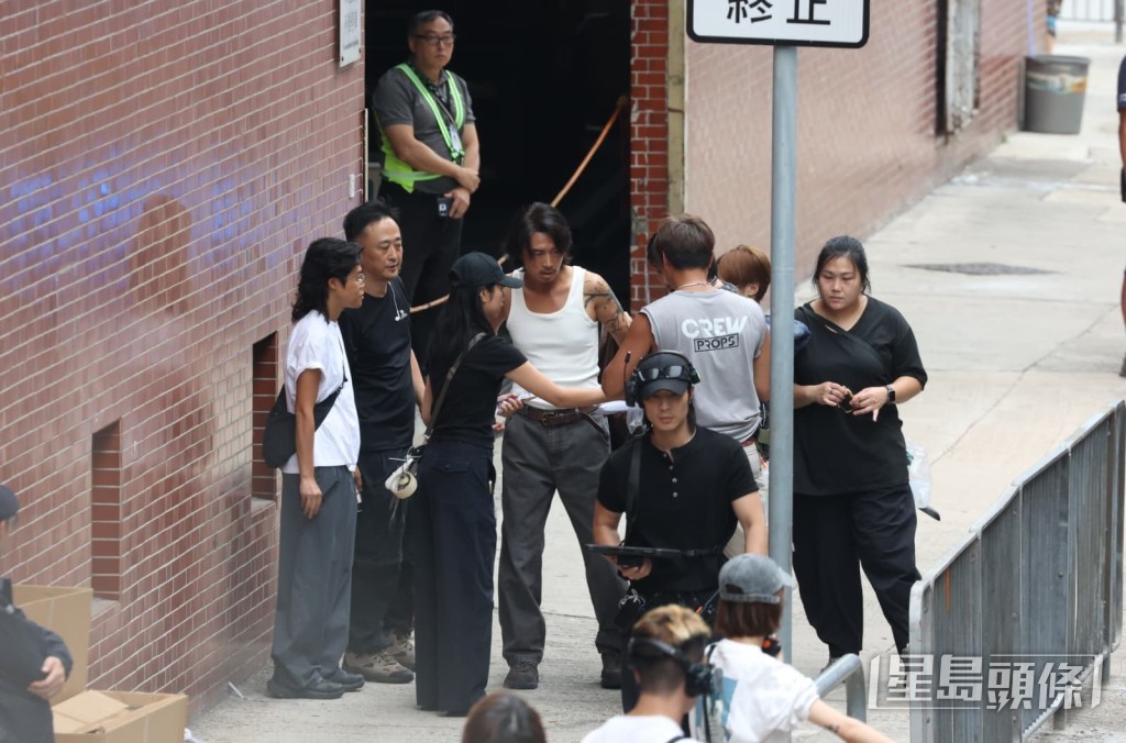 梳化服人員抓緊時間為身穿背心的黃子華整理儀容。