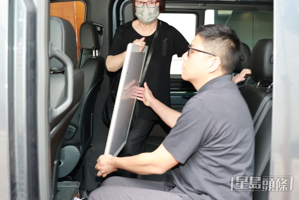 李兆熊的侄仔捧遺照上車。 李兆熊的侄仔捧遺照上車。