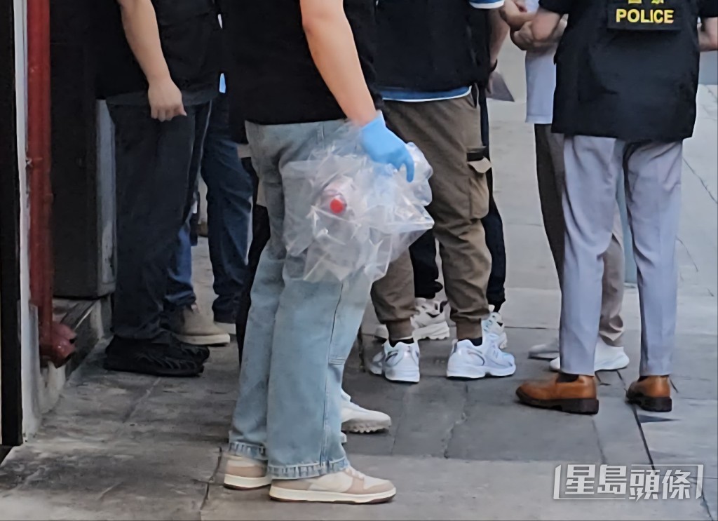 警員檢走一個空的通渠水樽。黃文威攝 警員檢走一個空的通渠水樽。黃文威攝