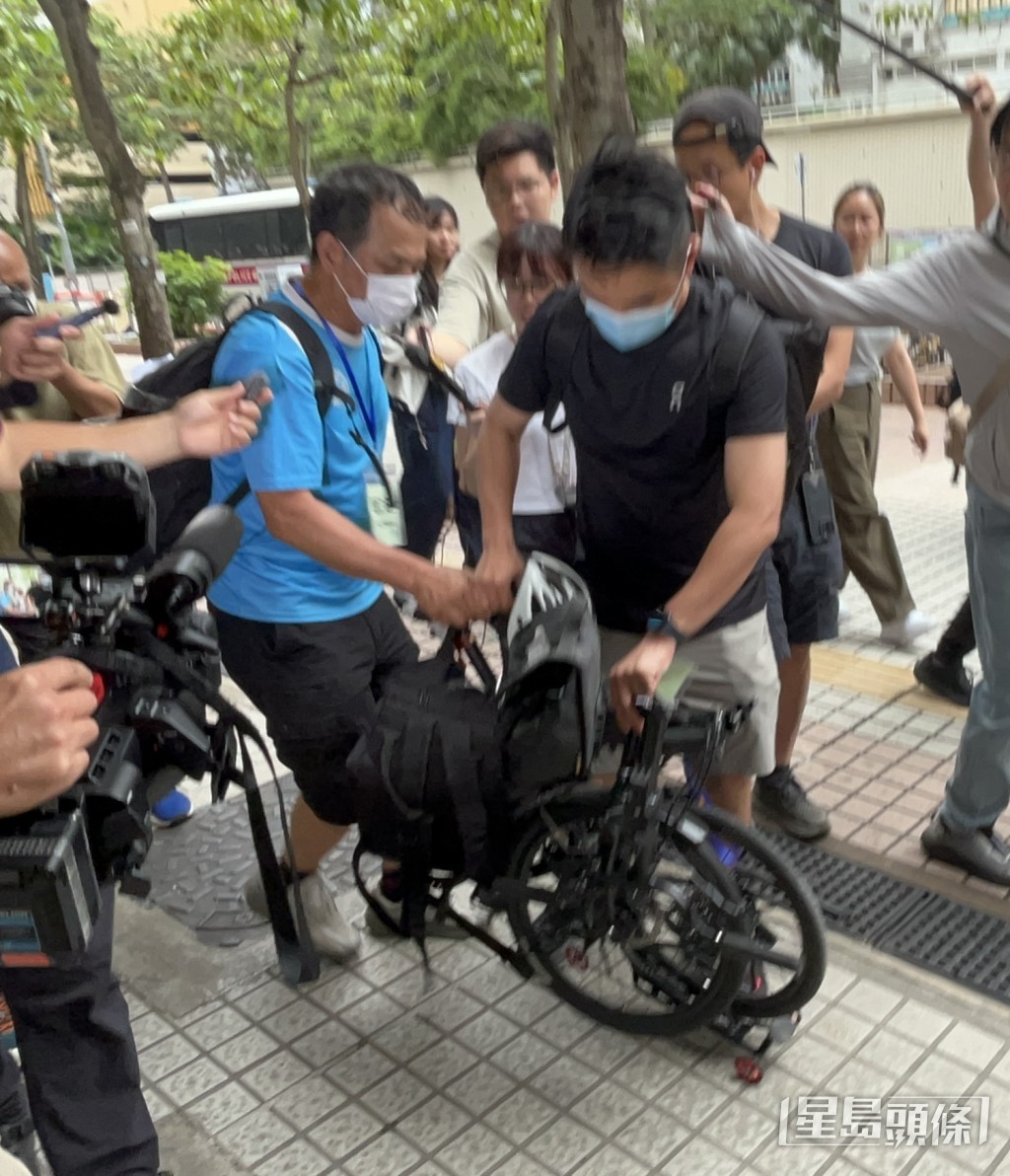 杨先生推著自行车离开。杨伟亨摄 杨先生推著自行车离开。杨伟亨摄