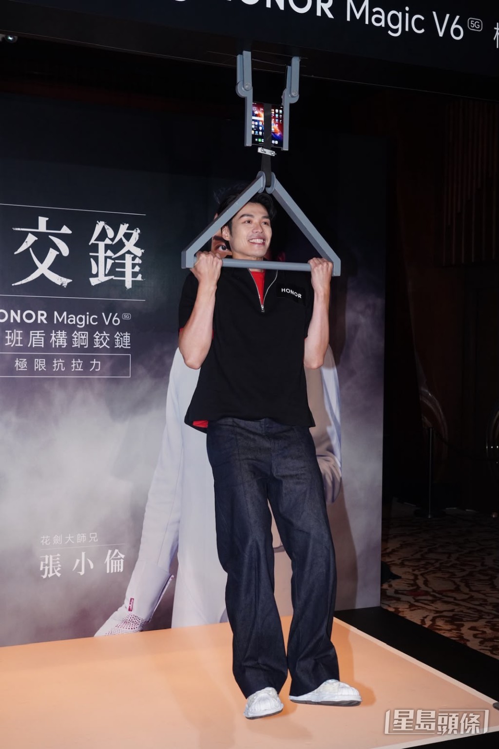 活動上張小倫在手機上掛上繩索做引體上升。 活動上張小倫在手機上掛上繩索做引體上升。