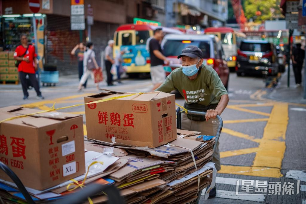 陸伯推着載滿紙皮的手推車,穿梭在人群與車輛之間。 陸伯推着載滿紙皮的手推車,穿梭在人群與車輛之間。