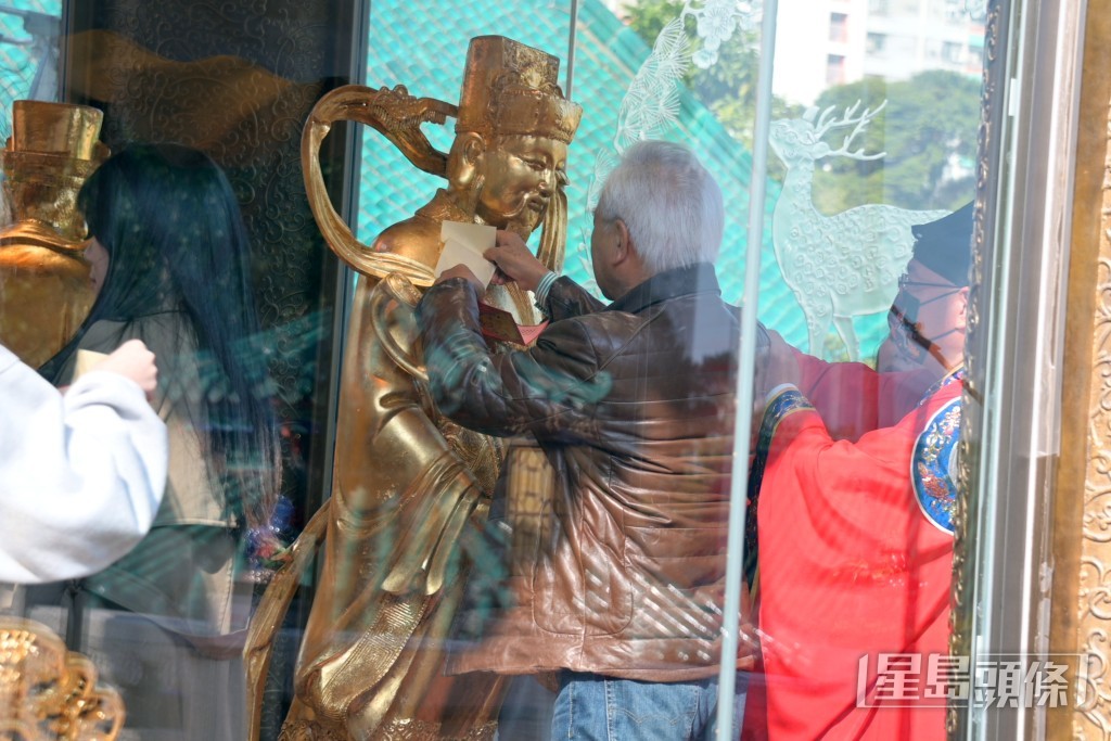 李龍基親手為財神像貼金身祈福。