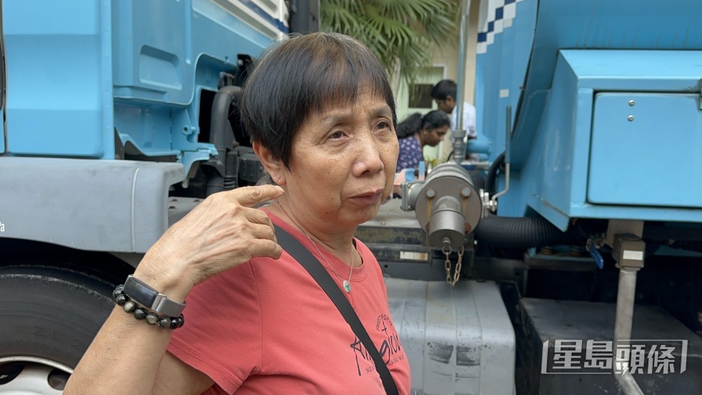 陳女士到水車載水給女兒梳洗返工。梁國峰攝