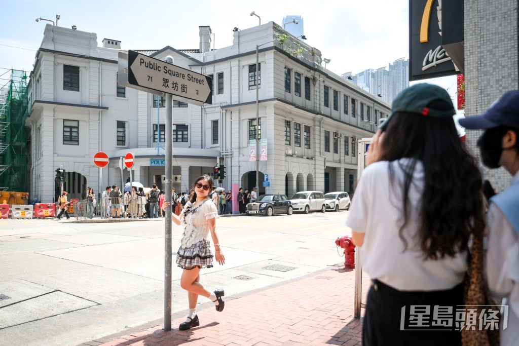 擠不到門口,對面街路牌也成打卡熱點。 擠不到門口,對面街路牌也成打卡熱點。