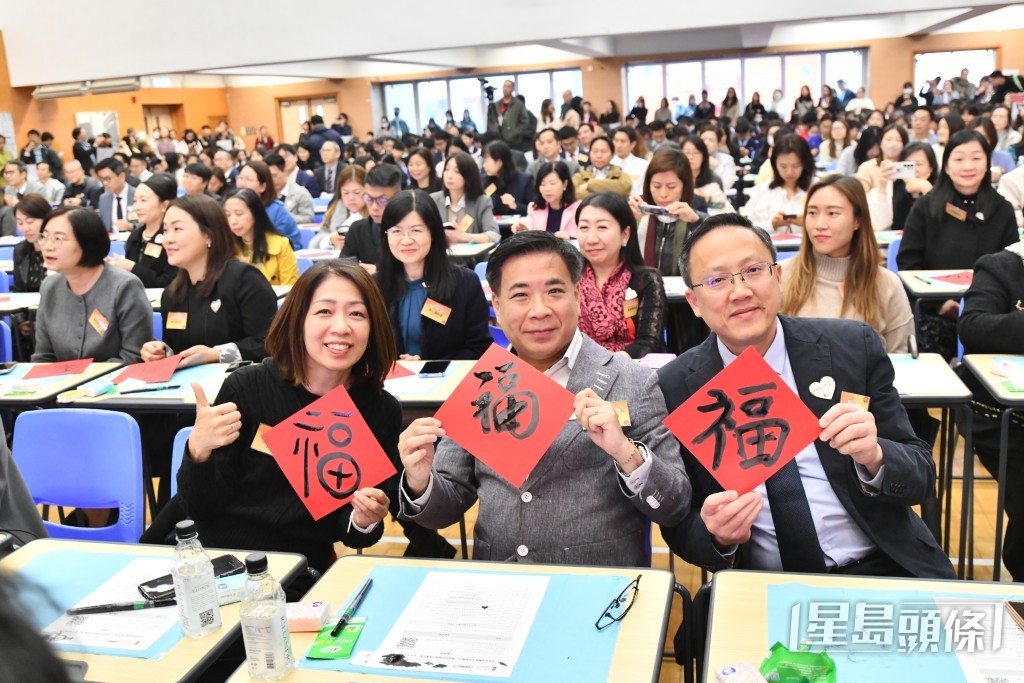 校长举起亲笔撰写的福字，向全港市民送上祝福。