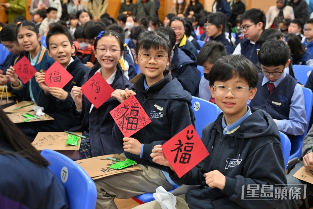 同学们开心展示自己手上的“福”字作品。