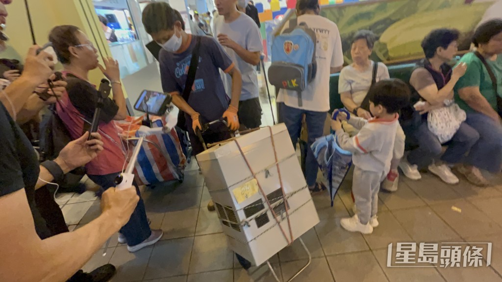 招先生搬走冷气机。 招先生搬走冷气机。