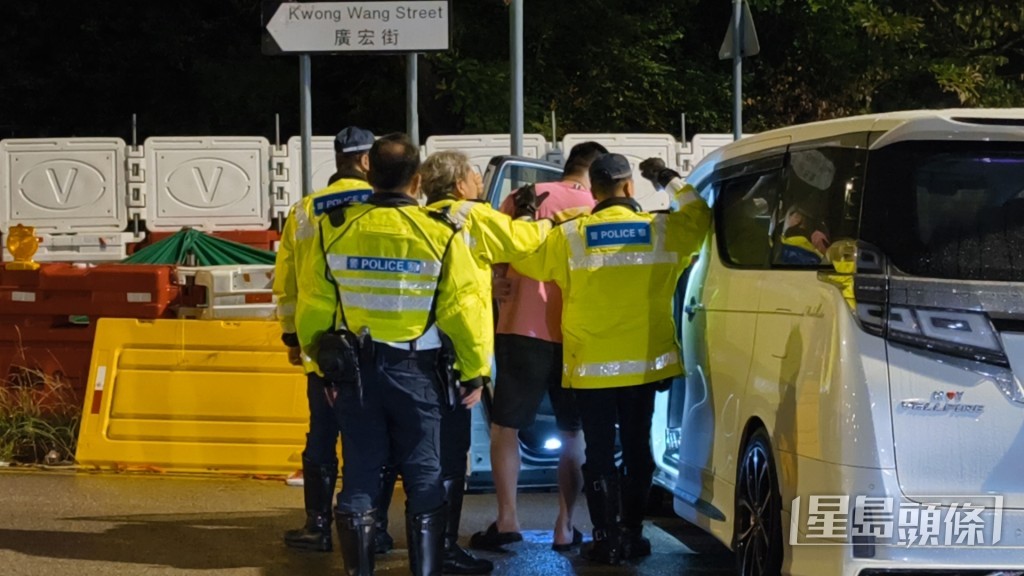 警员押解男司机至车辆搜查。 警员押解男司机至车辆搜查。