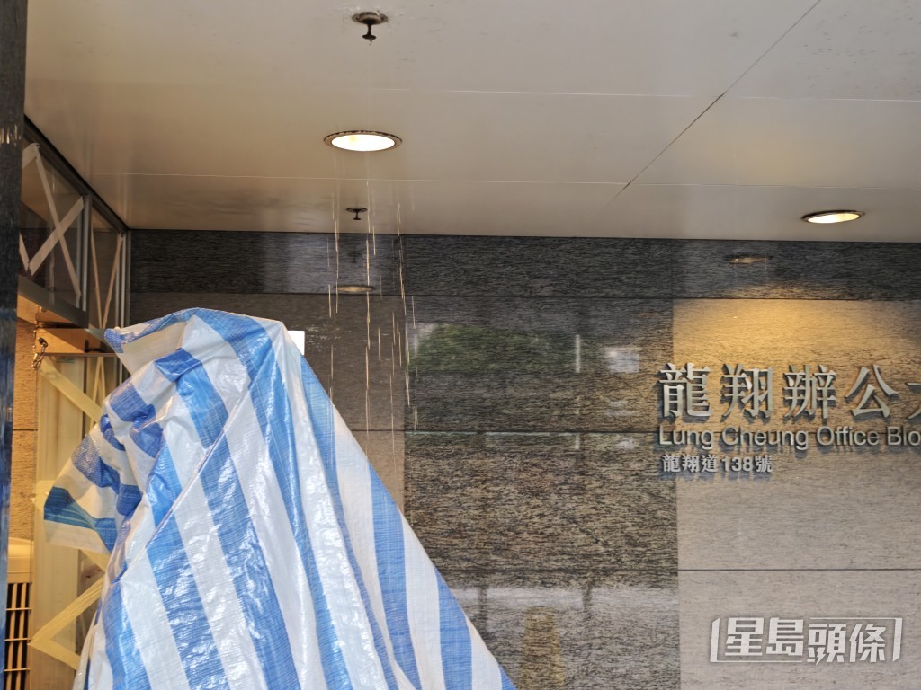 龍翔辦公大樓門外亦同樣遭殃，現場所見，職員用帆布將水柱擋住，以免流入辦公室。陳俊豪攝