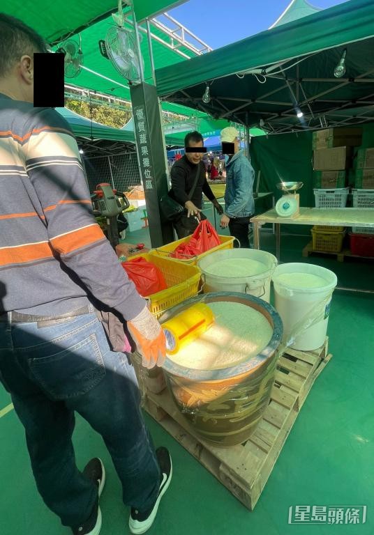 有本地農戶發現「高佬」（穿黑衣者）將多桶白米運到嘉年華攤檔。 受訪者提供