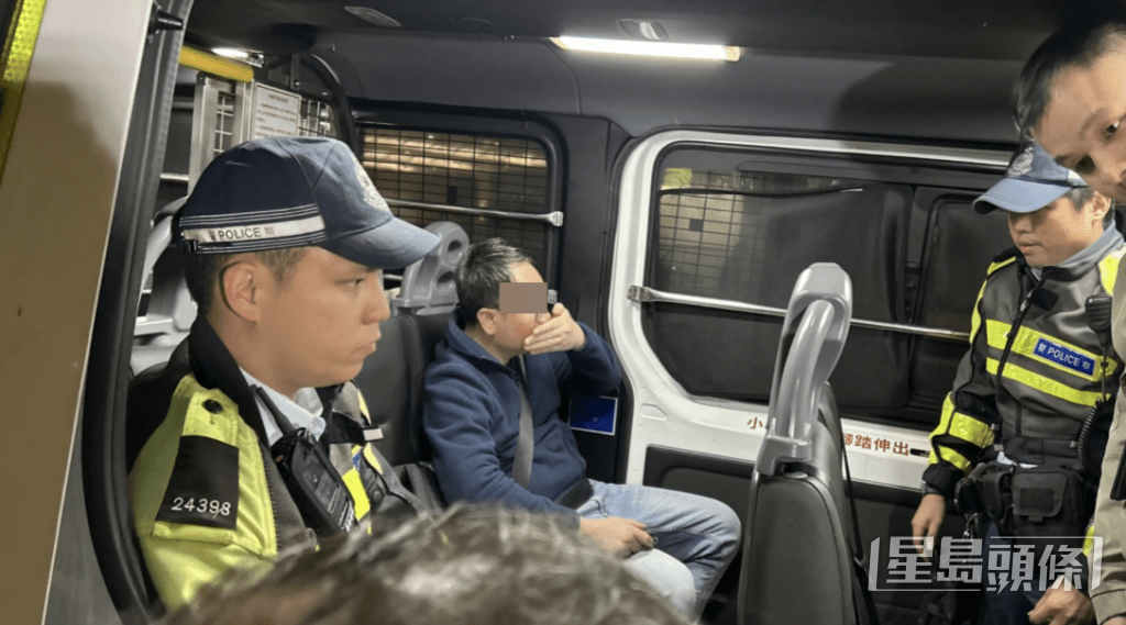 男司機被押上警車時以手掩口鼻。蔡楚輝攝 男司機被押上警車時以手掩口鼻。蔡楚輝攝