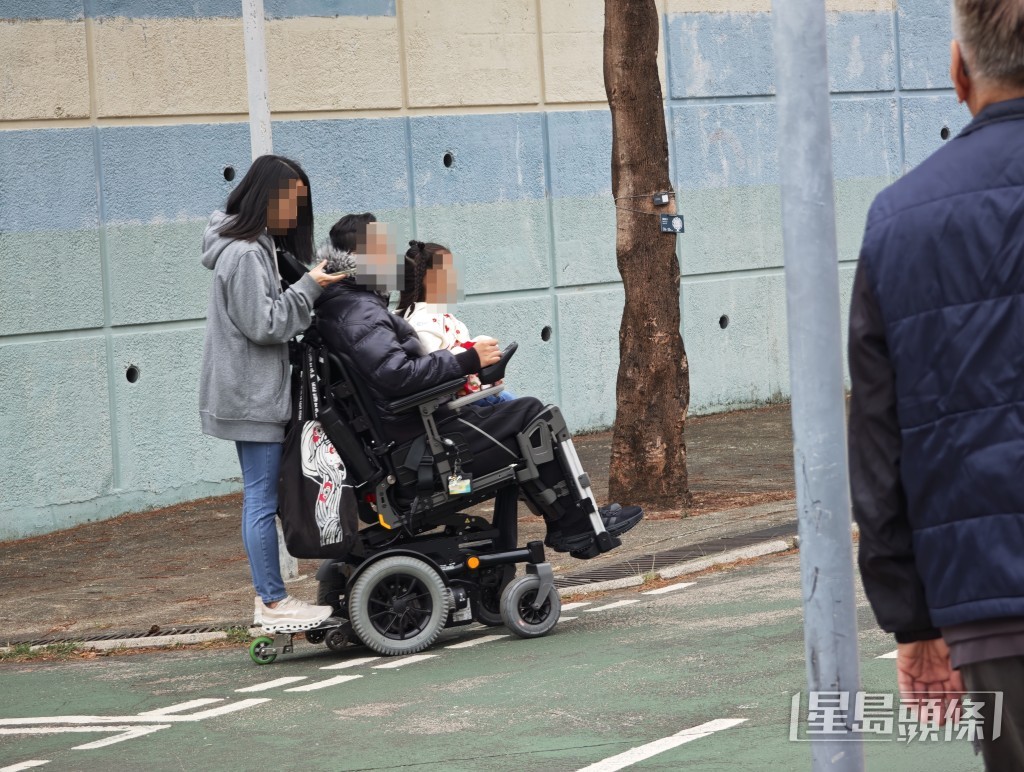 電動輪椅上不但有幼童坐在輪椅駕駛者的大腿上，車尾再多站一名女生。