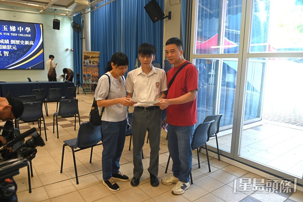 保良局董玉娣中學誕生「超級狀元」黃泓智與父母合照。林思明攝 保良局董玉娣中學誕生「超級狀元」黃泓智與父母合照。林思明攝
