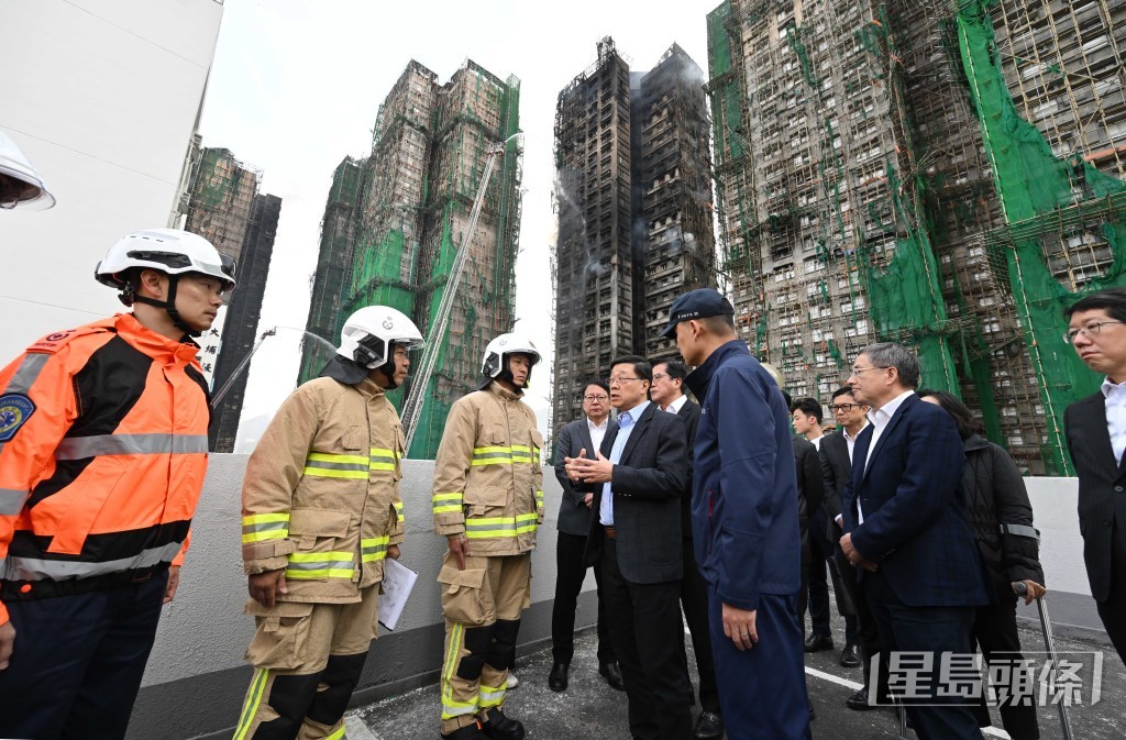 消防處處長楊恩健向特首李家超匯報火場最新進展。