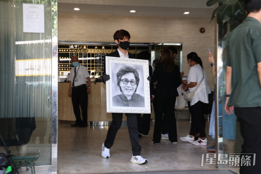 樂易玲的大仔捧著爸爸遺照登上靈車。 樂易玲的大仔捧著爸爸遺照登上靈車。