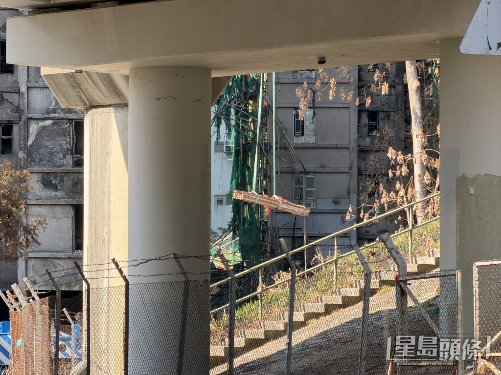 大型工程吊臂車將鐵架吊起，吊上宏昌閣樓上，準備為個別單位進行臨時加固工程。