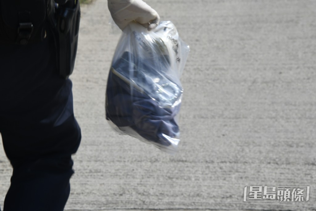 警員檢走死者個人物品。 警員檢走死者個人物品。