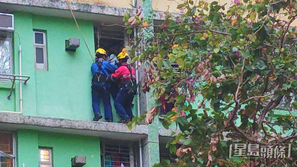 消防員內外夾擊將女事主抱救回屋內。蔡楚輝攝