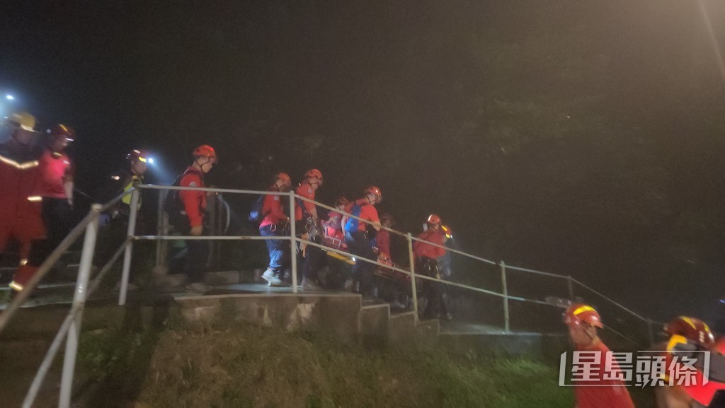 消防及民安隊人員將事主救下山。黎志偉攝 消防及民安隊人員將事主救下山。黎志偉攝