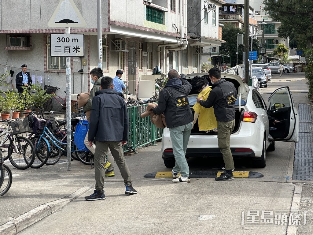 探員帶同代表死者的假公仔到場，進入涉案村屋單位。梁國峰攝