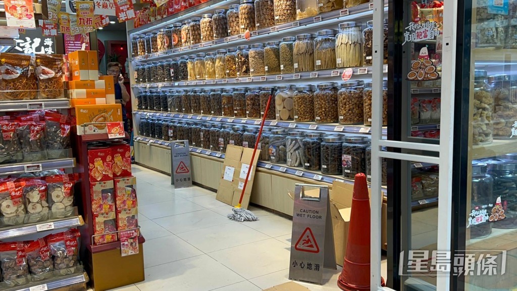 事後店員清理舖內積水。 事後店員清理舖內積水。