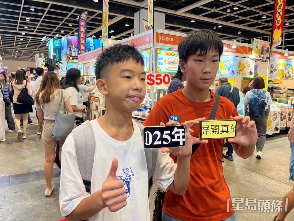 陳同學（左）及吳同學（右）展示用手機打出的「今日美食展覽開幕真的很興奮」字幕。