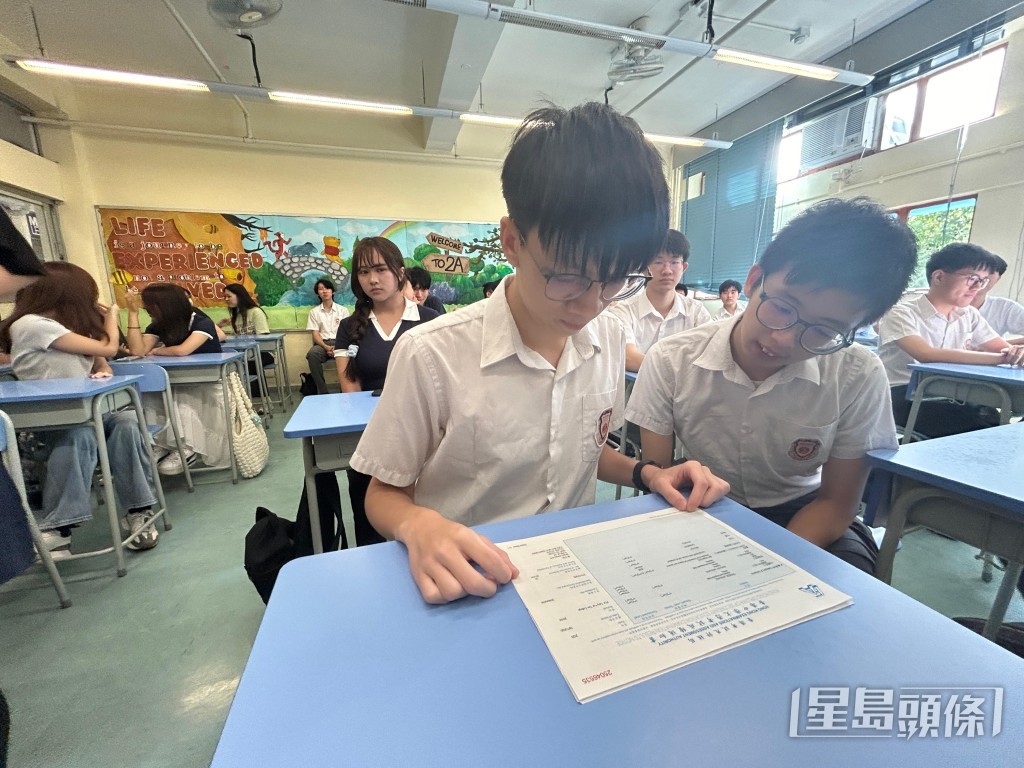 黃泓智(圖左)細閱成績單。 黃泓智(圖左)細閱成績單。