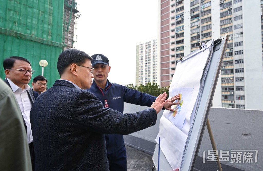 消防處處長楊恩健向特首李家超匯報火場最新進展。劉駿軒攝