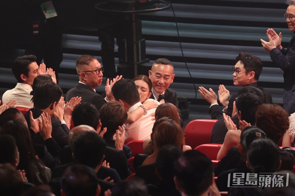 余香凝在台下拥抱老公及身旁的同行。  ​