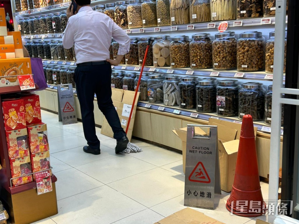 事後店員清理舖內積水。曾志恆攝 事後店員清理舖內積水。曾志恆攝