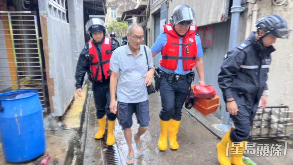 執法人員協助長者離開到安全地方。梁國峰攝