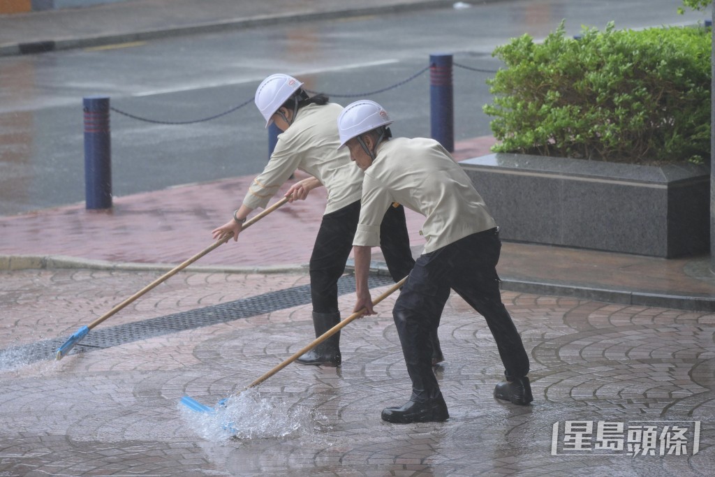 工作人員清理積水。 工作人員清理積水。