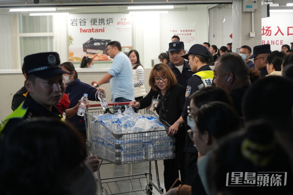 职员推出一车车樽装水向排队人士派发。吴艳玲摄