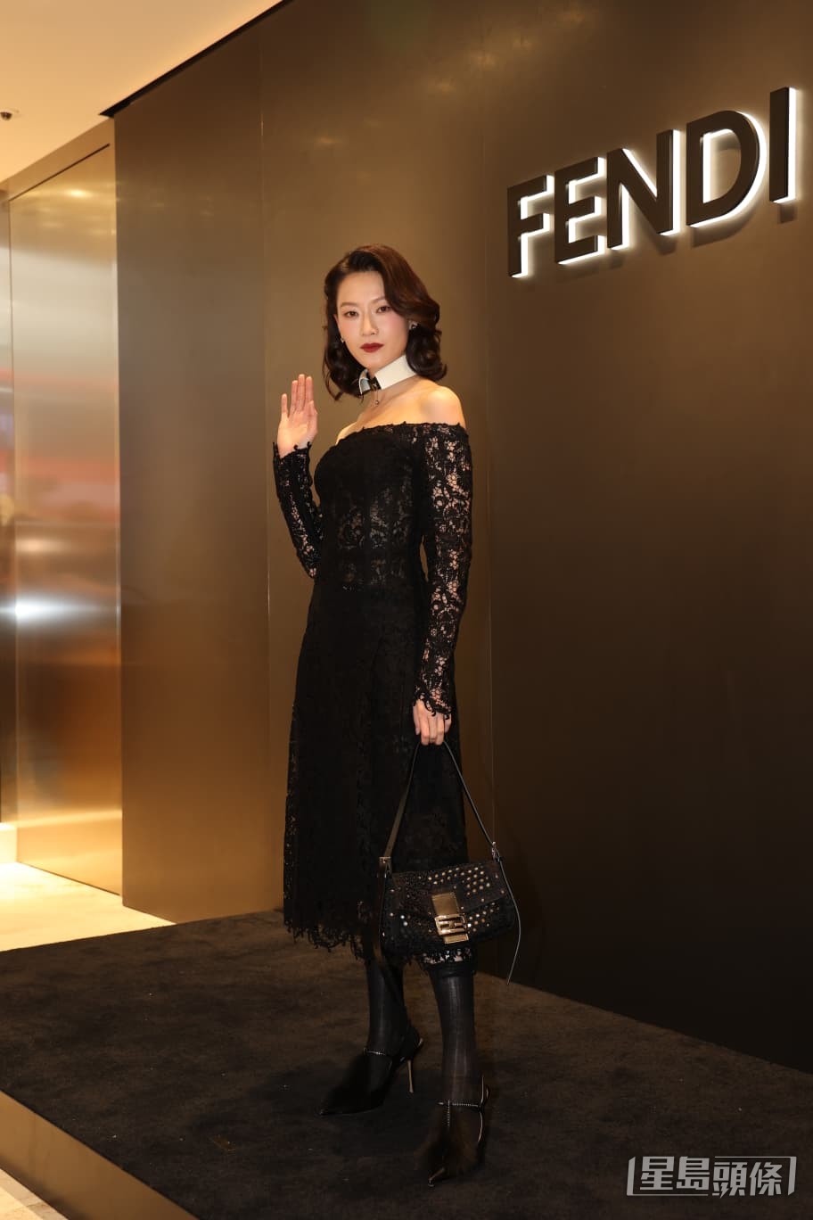 她一身黑色喱士裙，加上濃妝紅唇現身。