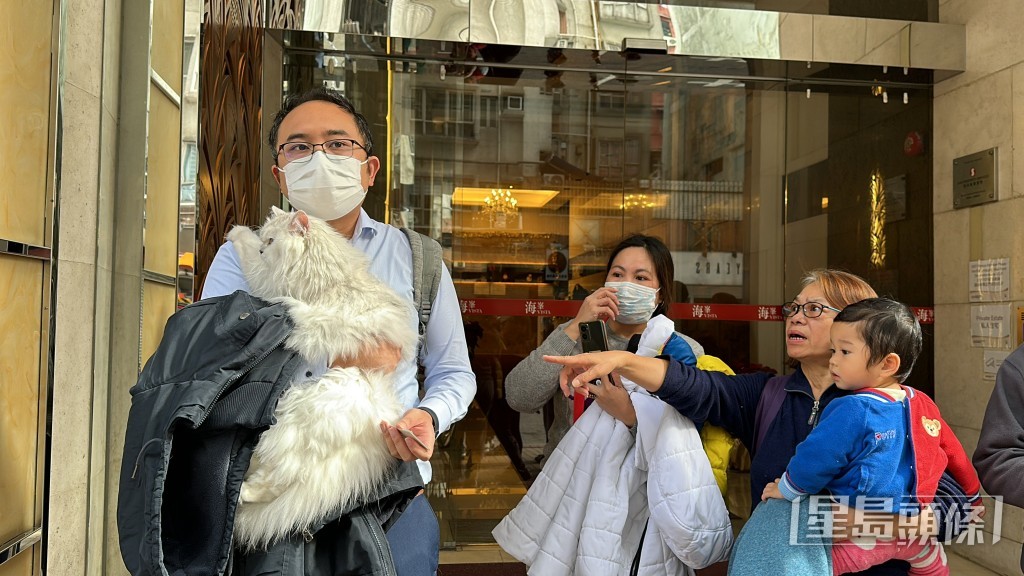 消防员救出一只猫交回男主人。刘汉权摄