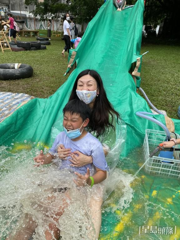 马慧敏鼓励儿子Ryan一同玩滑水梯。