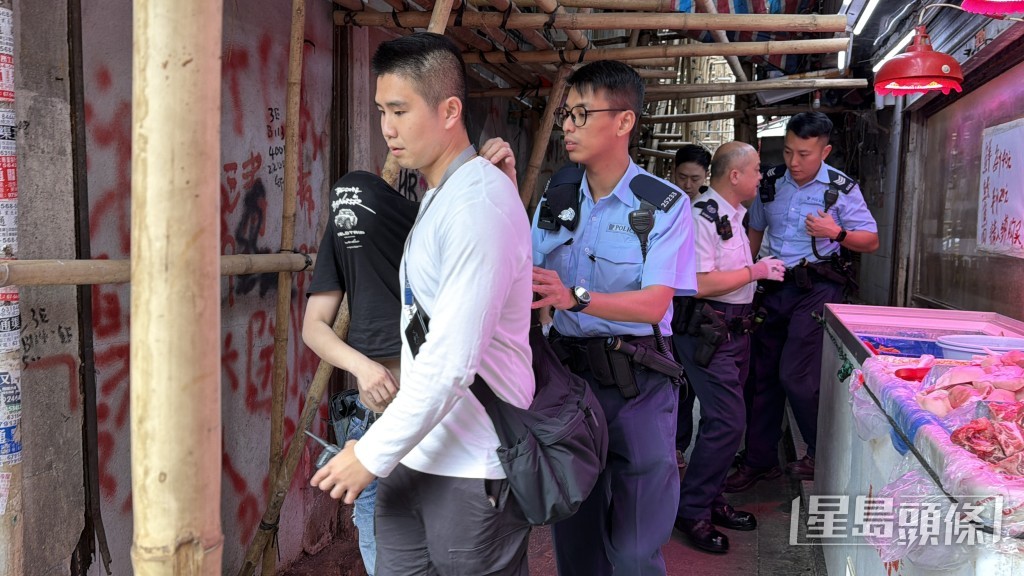 警員在現場帶走一名男子(黑衫遮頭)助查。