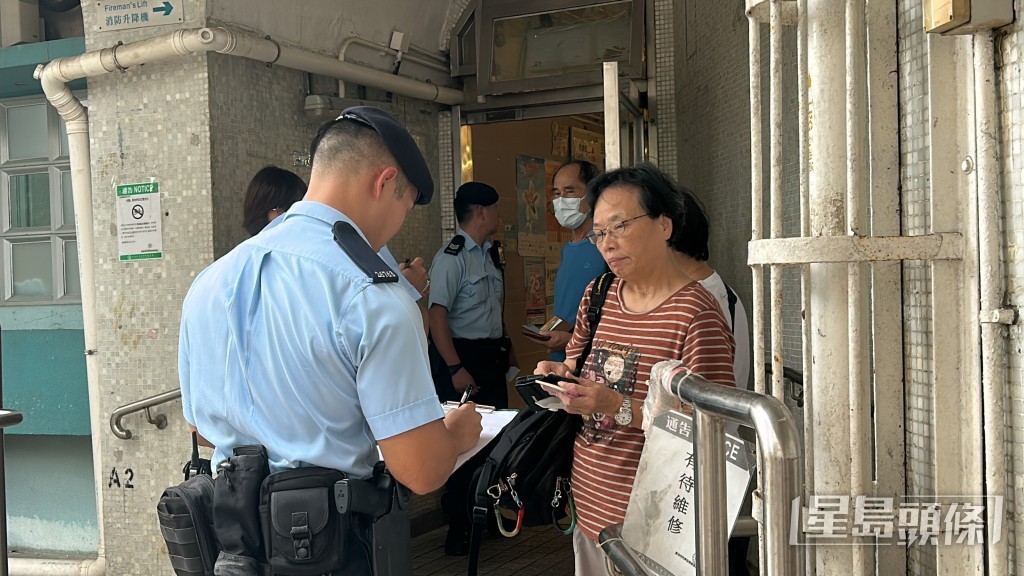 警察機動部隊在大廈出入口向居民登記並詢問是否住5號或7號室。