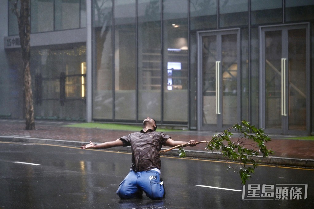 有人在路中心手持樹枝,雙腳跪地。劉駿軒攝 有人在路中心手持樹枝,雙腳跪地。劉駿軒攝